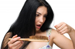 Woman losing hair on hairbrush